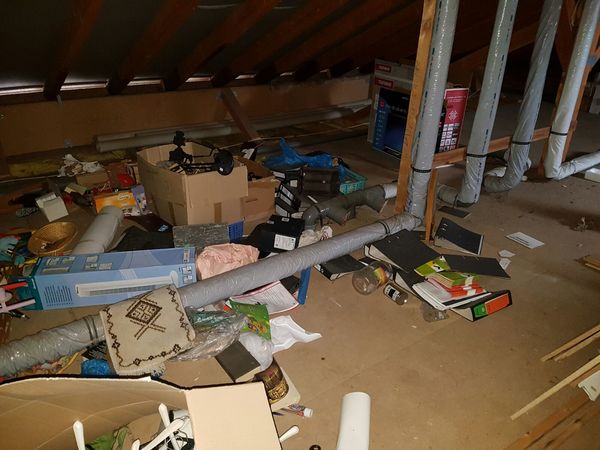 Dachboden mit chaotischer Lagerung, Kartons, Aktenordnern und Haushaltsgegenständen.